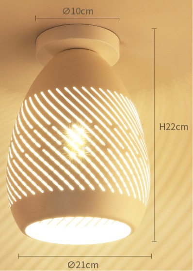 Teardrop-shaped white ceramic ceiling light with spiral cut design glowing warmly